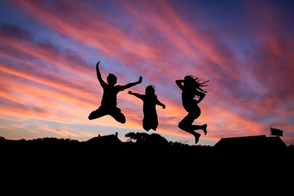 3 people jumping for joy at sunrise