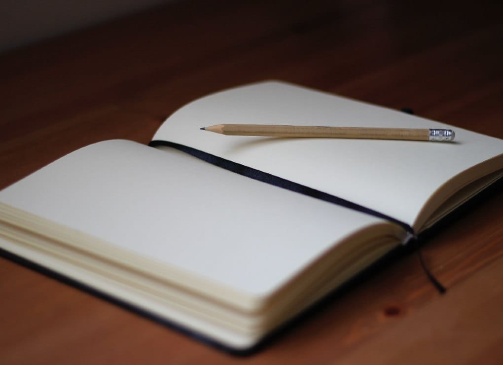 open blank journal with pencil